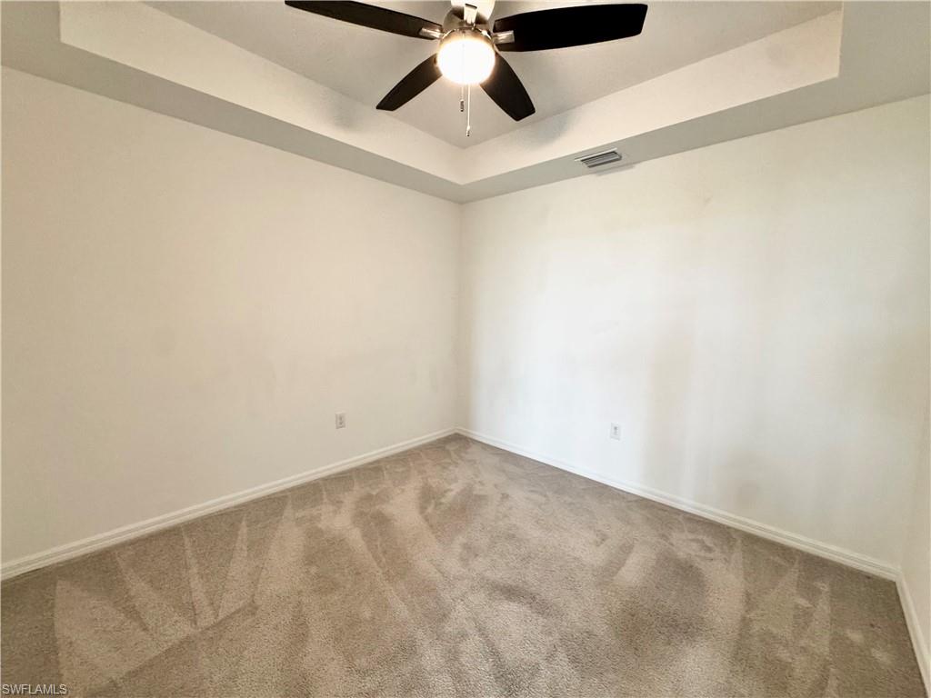 15970 Grassland Lane, Unit 2813 Babcock Ranch, FL 33982 - Photo 14 of 39 Carpeted spare room with ceiling fan and a raised ceiling