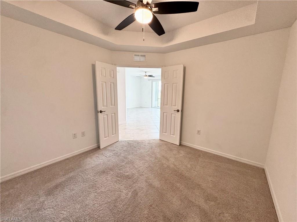 15970 Grassland Lane, Unit 2813 Babcock Ranch, FL 33982 - Photo 15 of 39 Spare room featuring ceiling fan, a raised ceiling, and carpet floors