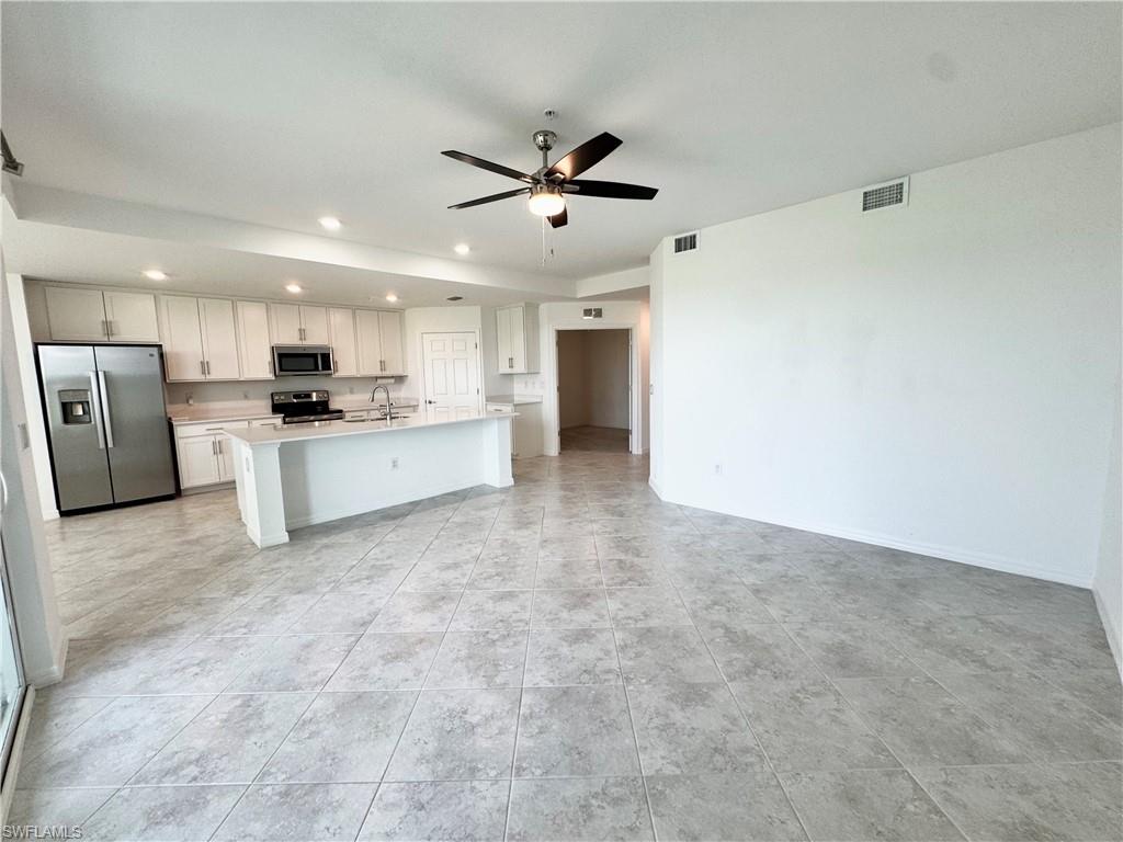 15970 Grassland Lane, Unit 2813 Babcock Ranch, FL 33982 - Photo 16 of 39 Kitchen with white cabinetry, ceiling fan, sink, a center island with sink, and appliances with stainless steel finishes