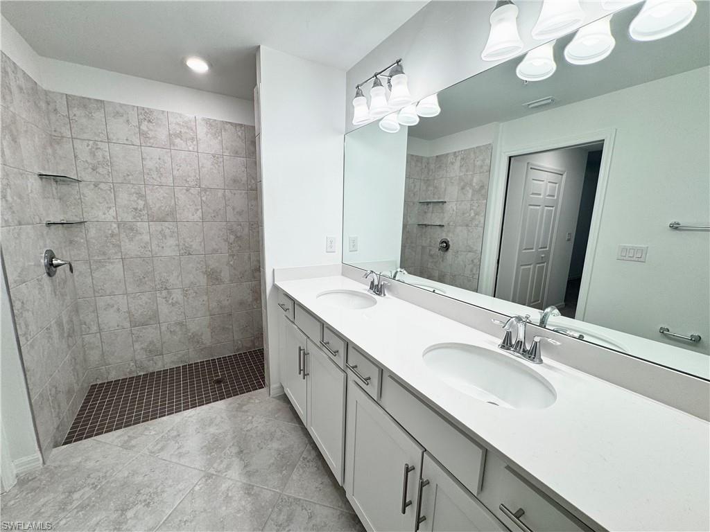 15970 Grassland Lane, Unit 2813 Babcock Ranch, FL 33982 - Photo 9 of 39 Bathroom featuring a tile shower, tile patterned flooring, and vanity
