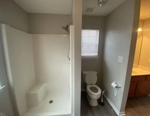 a bathroom with a toilet and a shower