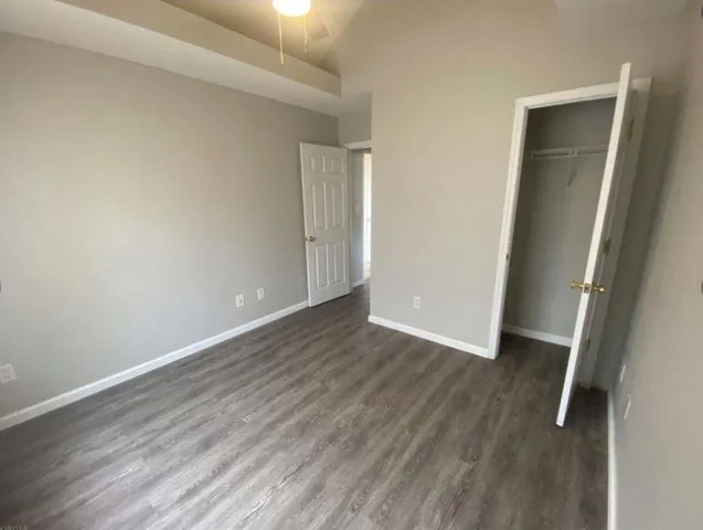 an empty room with wooden floor and closet