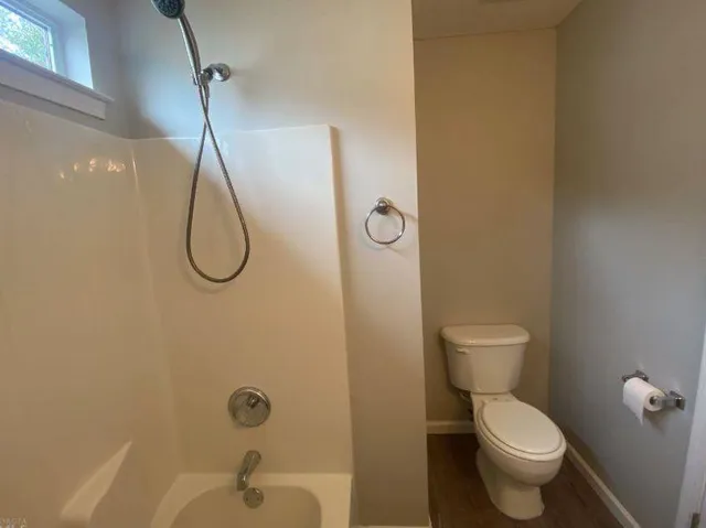 a bathroom with a toilet and a shower