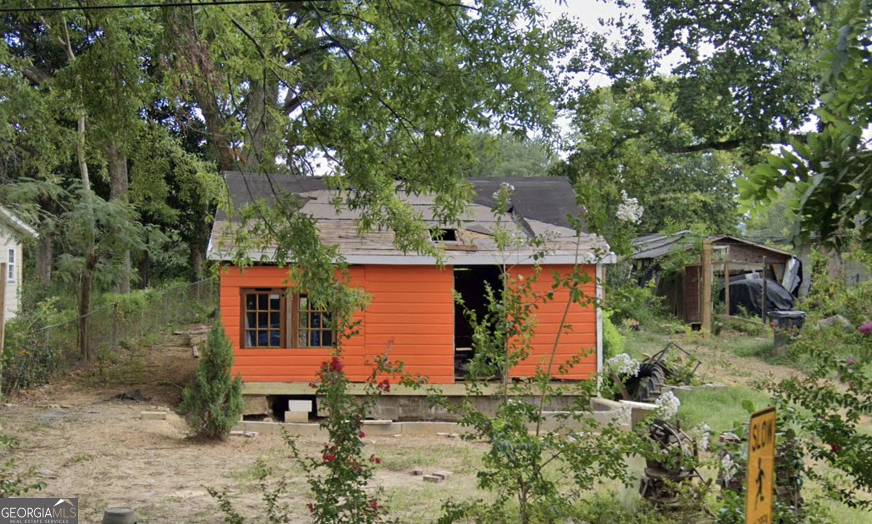 an aerial view of a house with yard and trees around