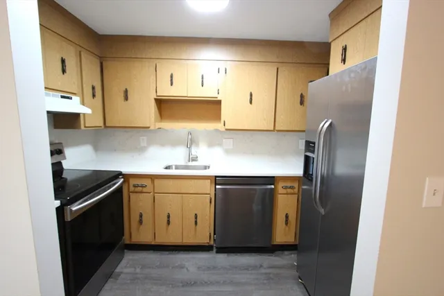 a kitchen with stainless steel appliances granite countertop a sink stove and microwave