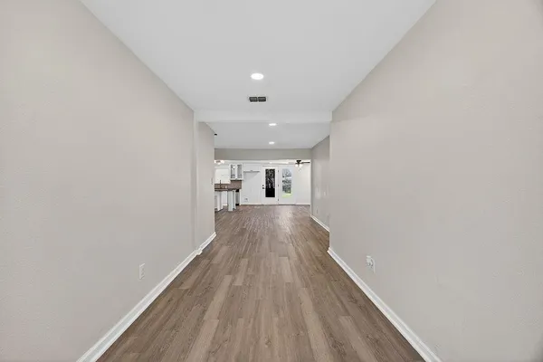 a view of a big room with wooden floor and a hallway