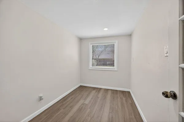a view of a room with wooden floor and window