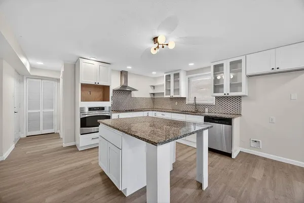a kitchen with stainless steel appliances granite countertop a sink stove and refrigerator