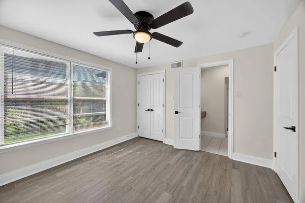 a view of an empty room with a window and wooden floor
