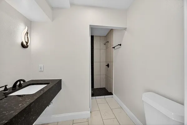 a bathroom with a granite countertop sink toilet and shower