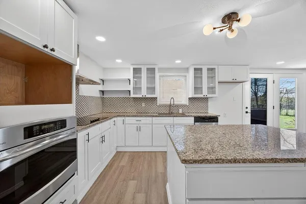 a kitchen with granite countertop cabinets stainless steel appliances and a counter space