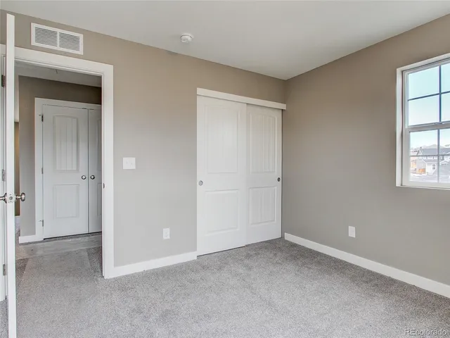 an empty room with windows and closet
