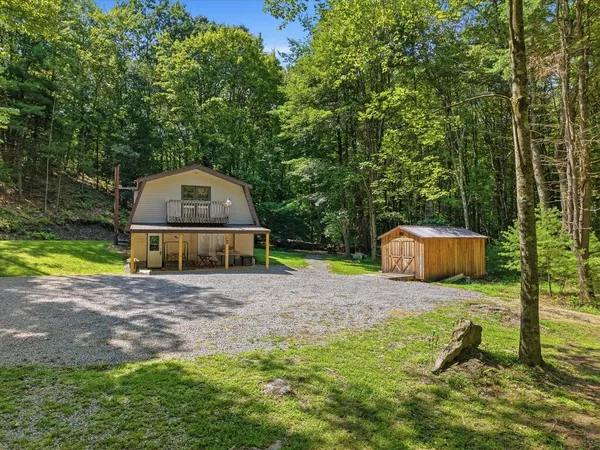 a wooden house with tall trees in the background