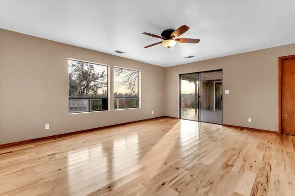 an empty room with windows and fan