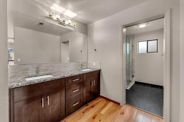 a bathroom with a granite countertop sink and a mirror