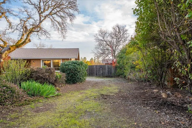a view of a house with a yard and potted plants
