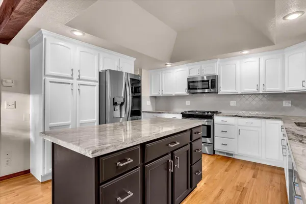 a kitchen with granite countertop white cabinets and appliances