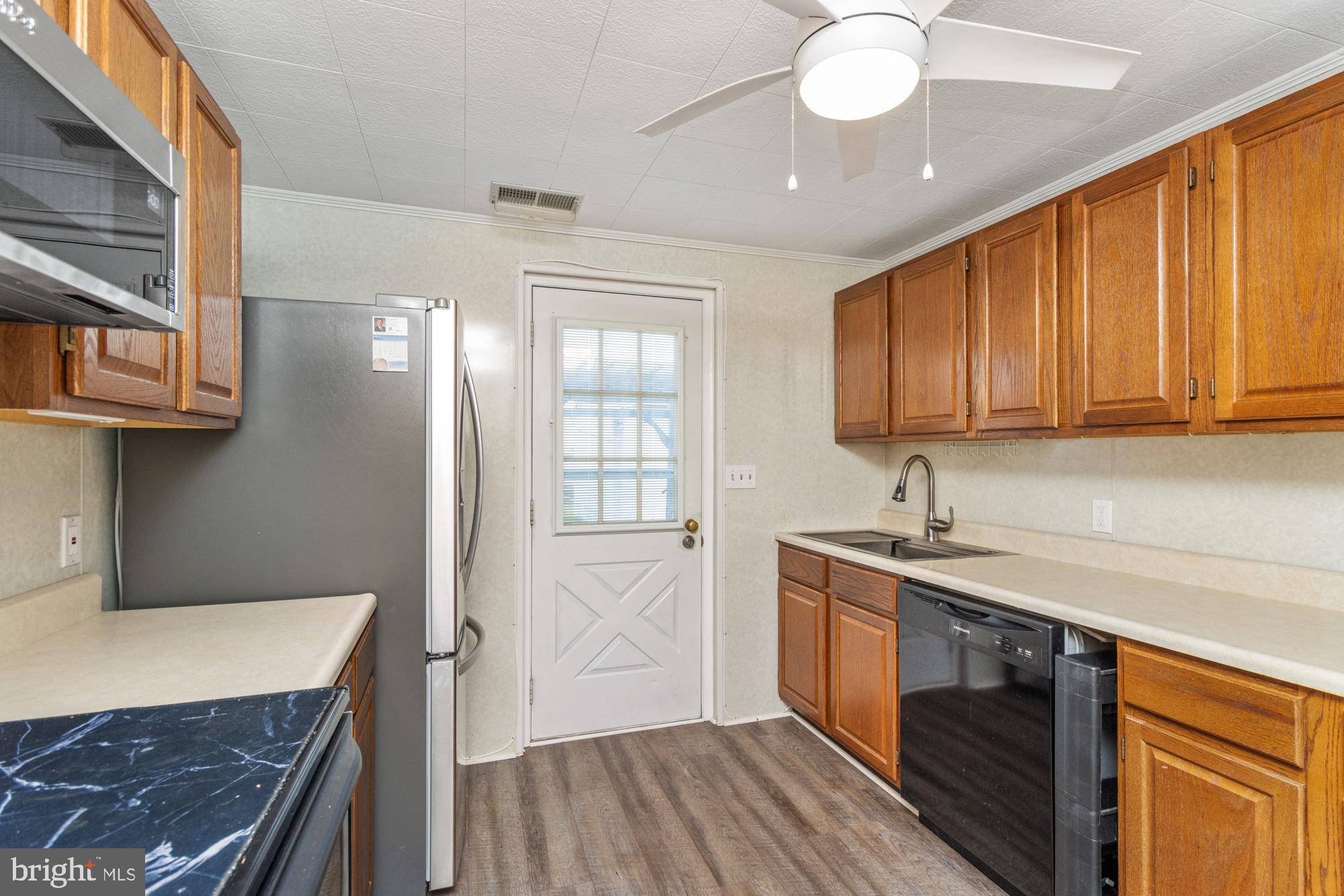 3135 Sollers Point Road Baltimore, MD 21222 - Photo 12 of 36 a kitchen with stainless steel appliances granite countertop a sink and cabinets with wooden floor