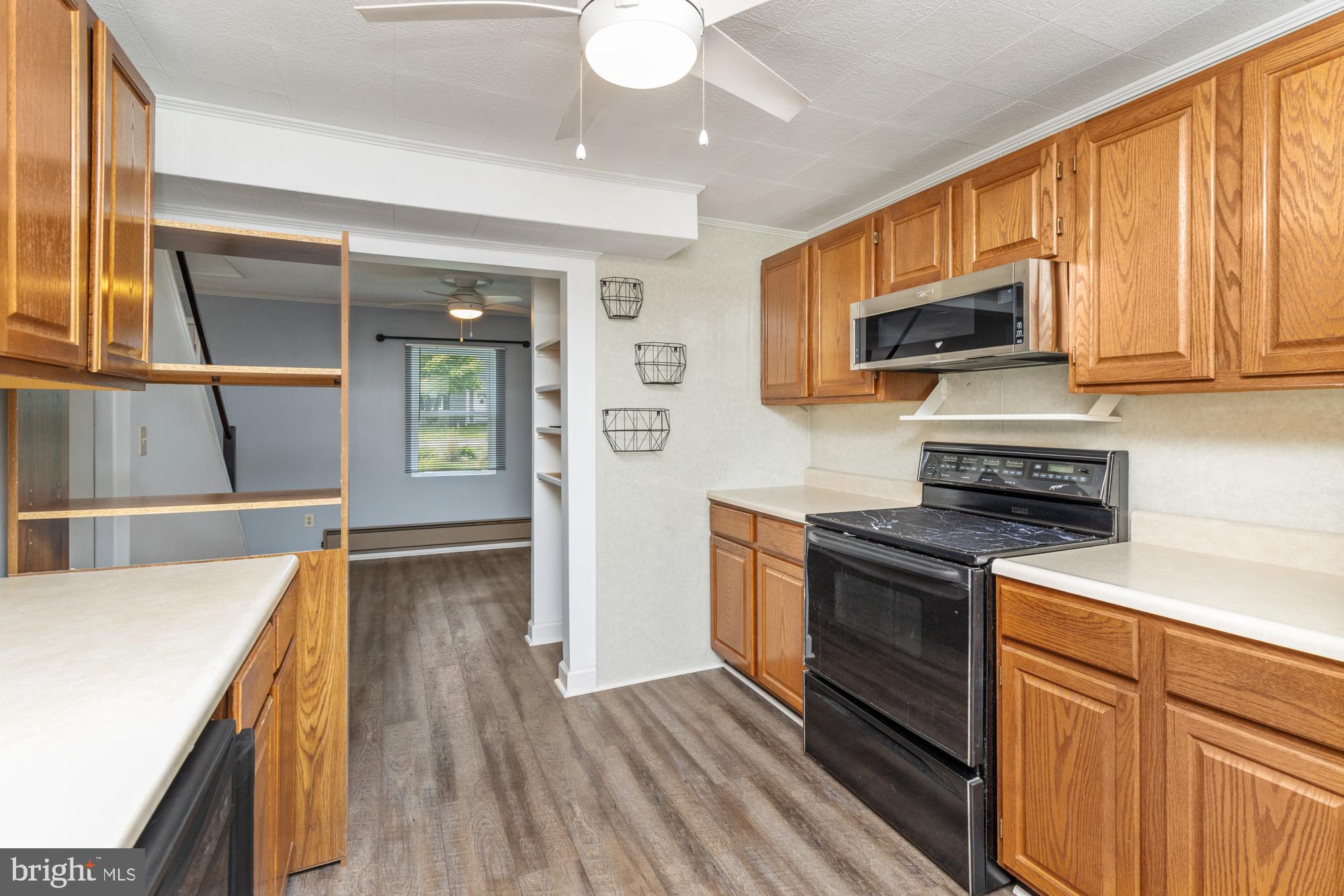 3135 Sollers Point Road Baltimore, MD 21222 - Photo 13 of 36 a kitchen with stainless steel appliances granite countertop a refrigerator a stove top oven a sink dishwasher and wooden floor