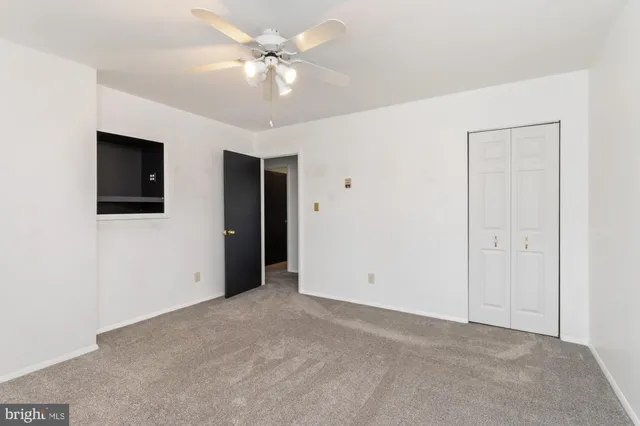 a view of an empty room with a ceiling fan