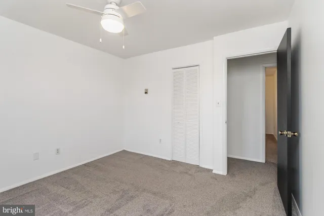 an empty room with a ceiling fan and a window