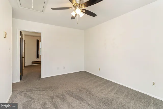 an empty room with closet and a chandelier fan