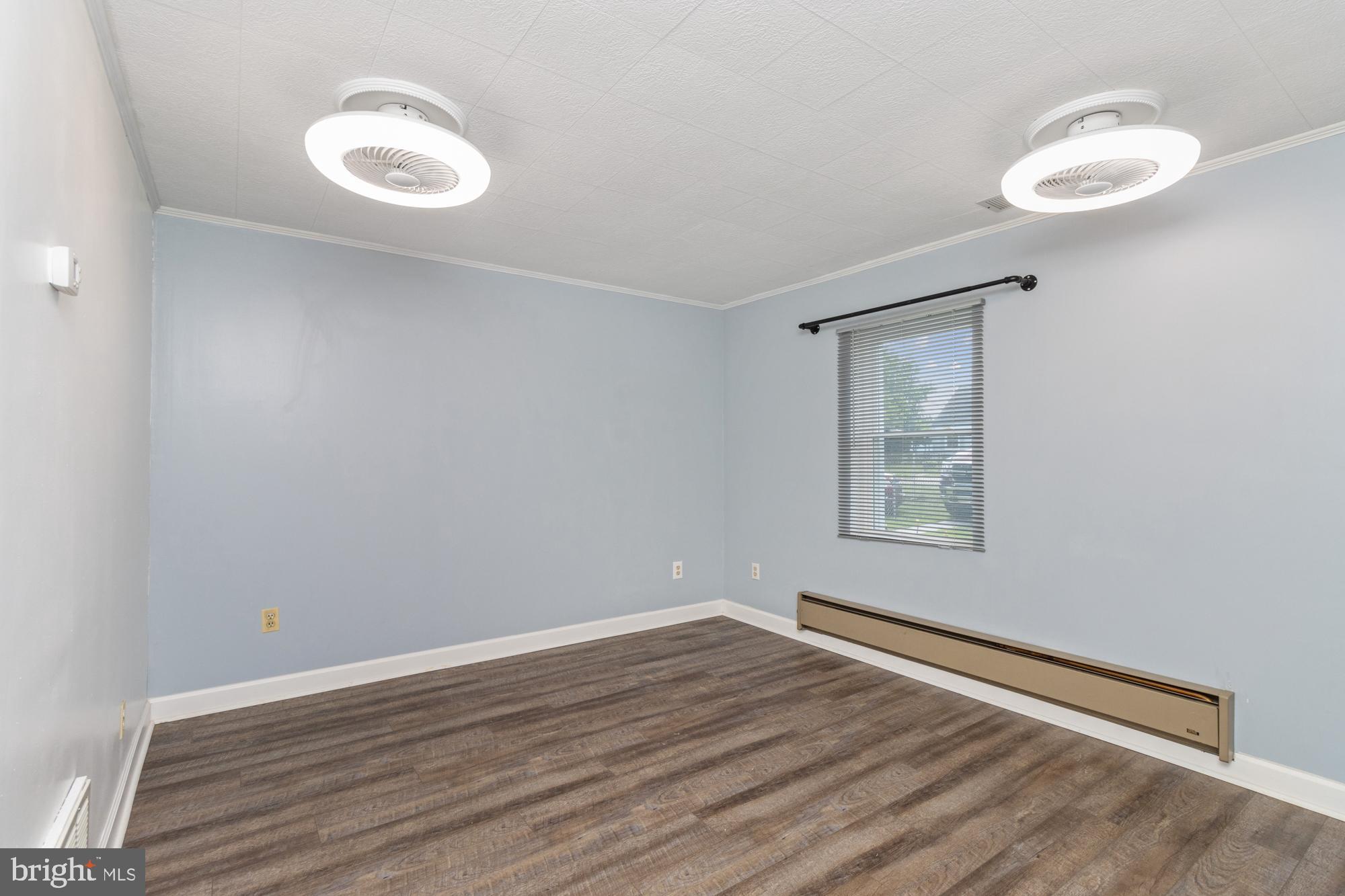 3135 Sollers Point Road Baltimore, MD 21222 - Photo 3 of 36 a view of an empty room with a window and wooden floor