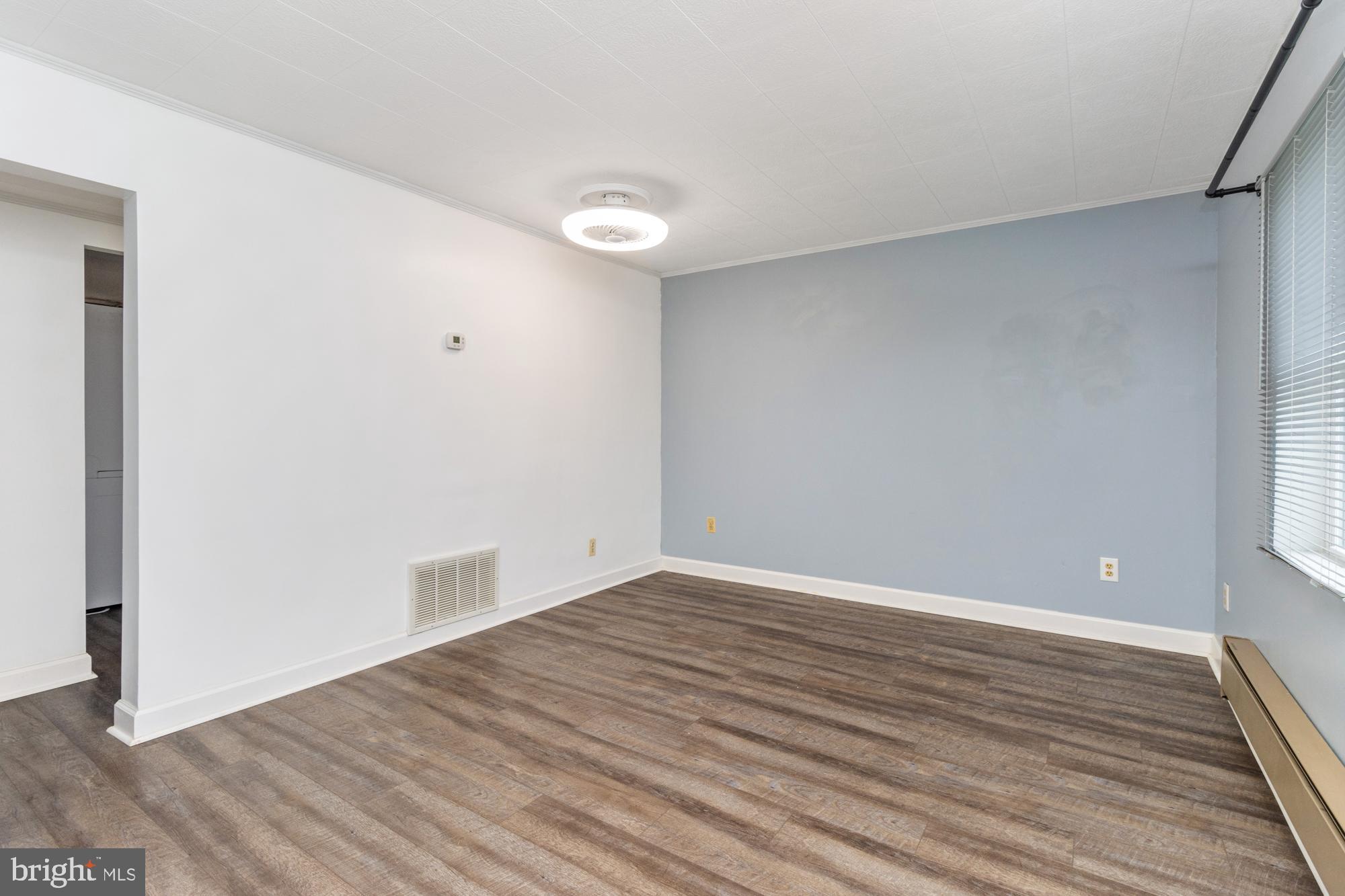 3135 Sollers Point Road Baltimore, MD 21222 - Photo 4 of 36 a view of an empty room with wooden floor and a window