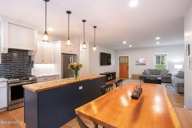 a kitchen with stainless steel appliances granite countertop a sink counter space and living room view