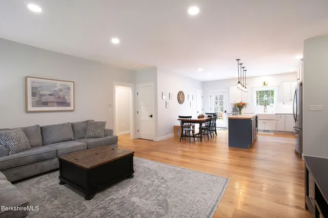 a living room with furniture and a dining table with kitchen view