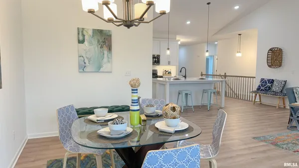 a view of a dining room with furniture a chandelier and wooden floor