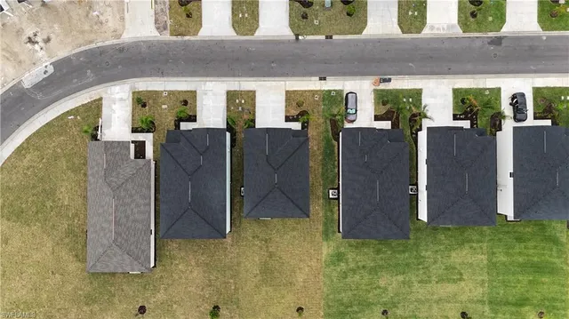 an aerial view of residential houses with outdoor space and pool