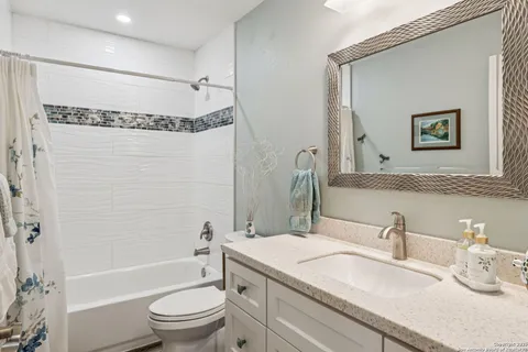 a bathroom with a granite countertop sink toilet and shower