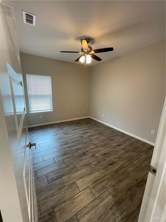 912 Kentucky Street Alton, TX 78573 - Photo 18 of 21 an empty room with wooden floor fan and windows