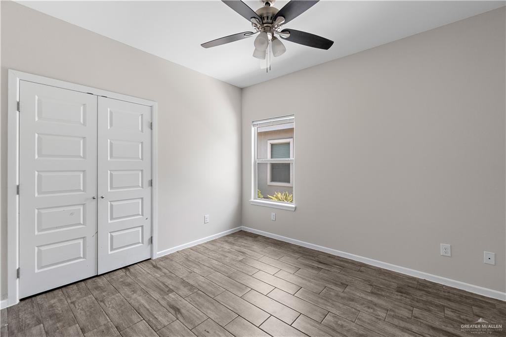 912 Kentucky Street Alton, TX 78573 - Photo 10 of 21 a view of an empty room with a window and wooden floor