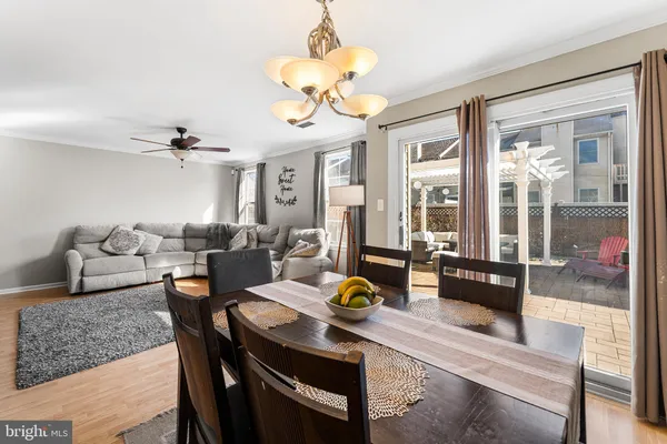 a living room with furniture a chandelier and a dining table