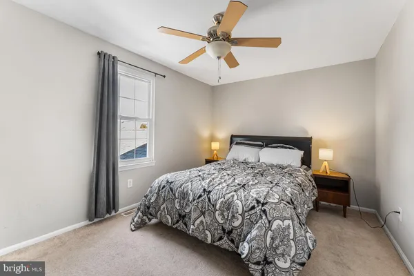 a bedroom with a bed and a ceiling fan