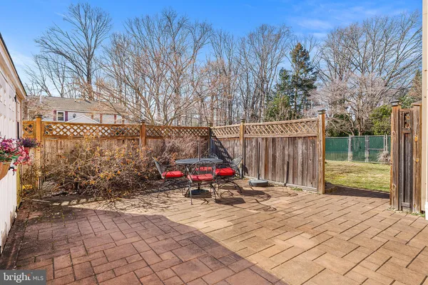 a view of roof deck with wooden fence and large trees