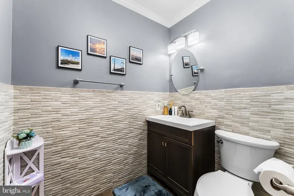 a bathroom with a toilet sink vanity and mirror