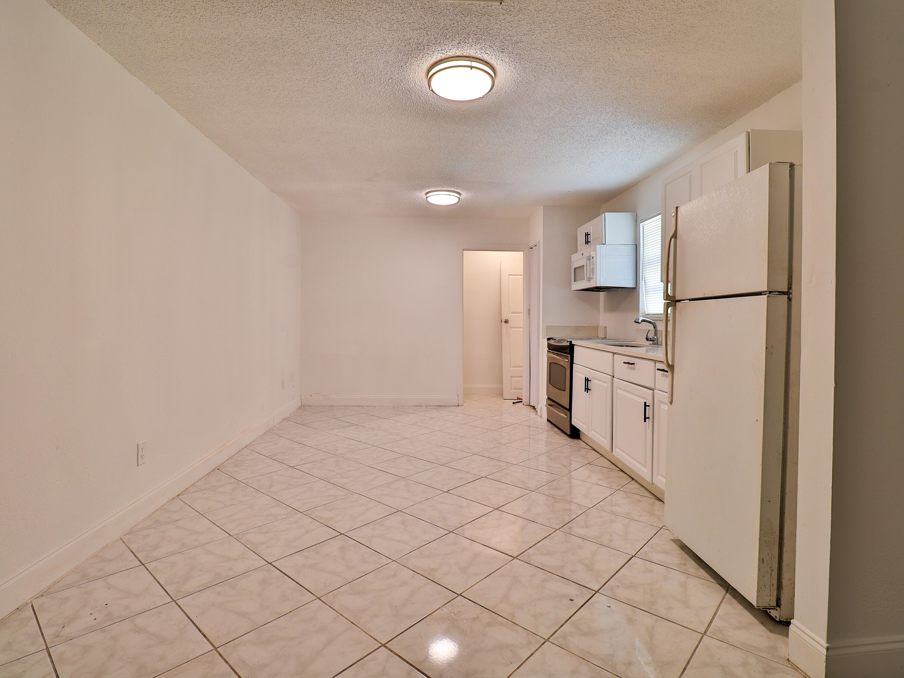 3024 West Dixie Boulevard Fort Pierce, FL 34946 - Photo 15 of 26 a kitchen with white cabinets and white appliances