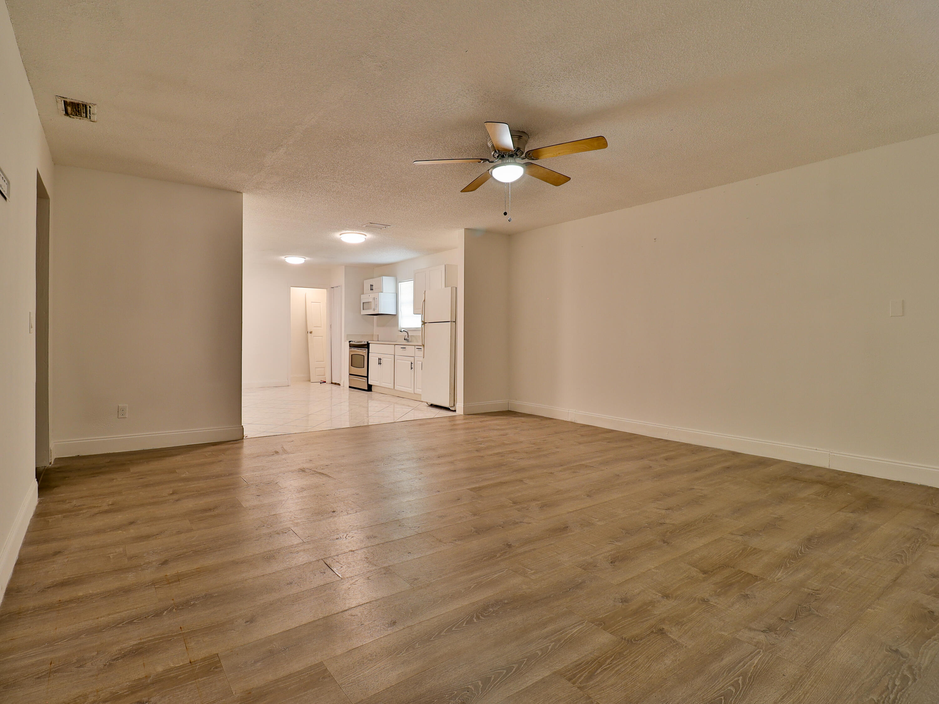 3024 West Dixie Boulevard Fort Pierce, FL 34946 - Photo 17 of 26 wooden floor in an empty room with a window