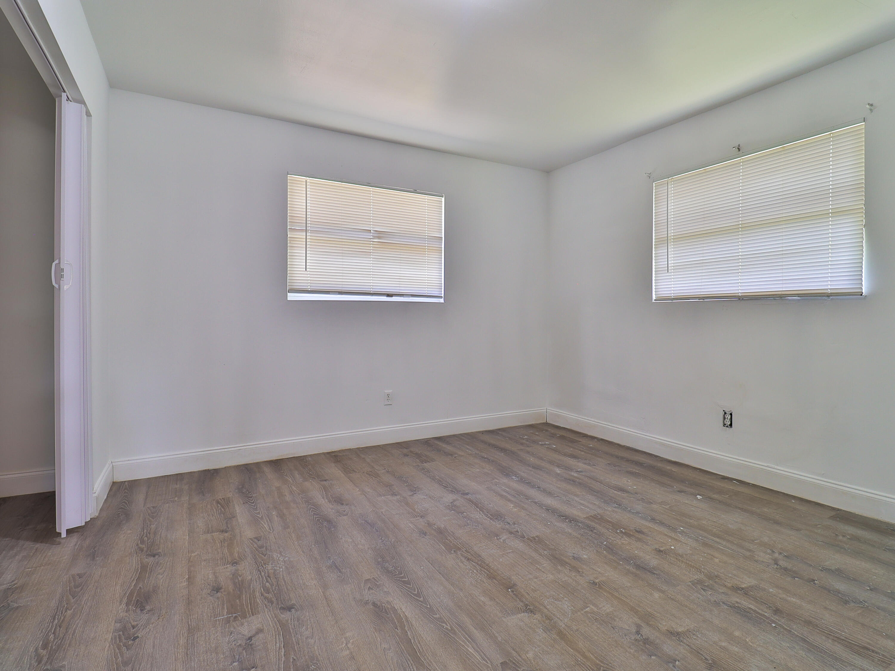 3024 West Dixie Boulevard Fort Pierce, FL 34946 - Photo 25 of 26 an empty room with wooden floor and windows