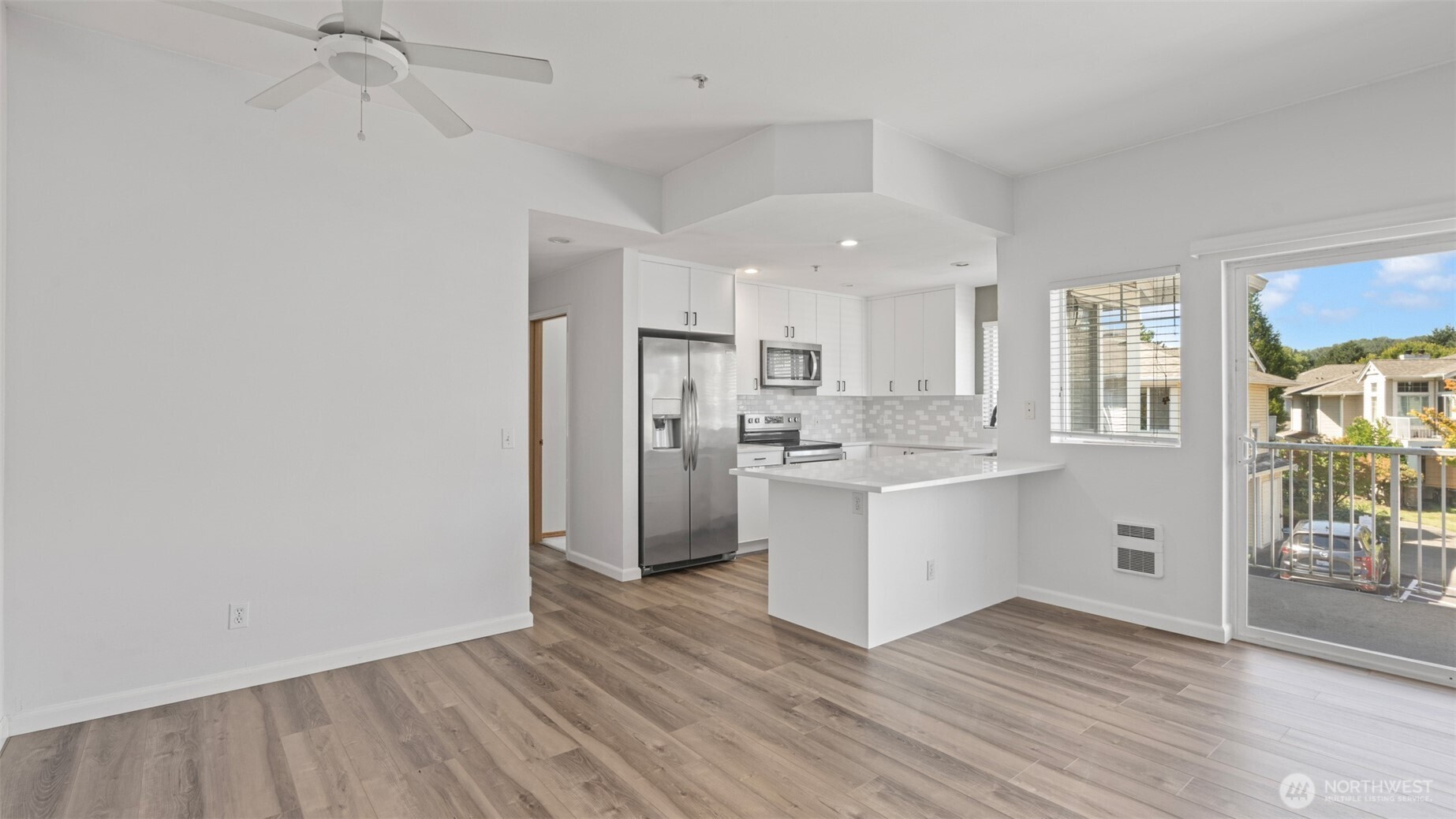 23118 59th Place South, Unit 154 Kent, WA 98032 - Photo 4 of 25 a kitchen with white cabinets and wooden floor