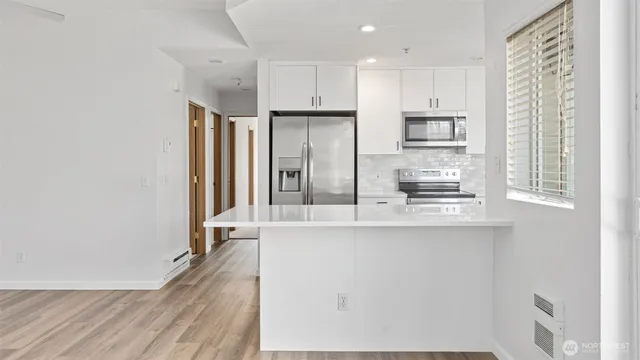 a kitchen with stainless steel appliances a refrigerator and a stove top oven