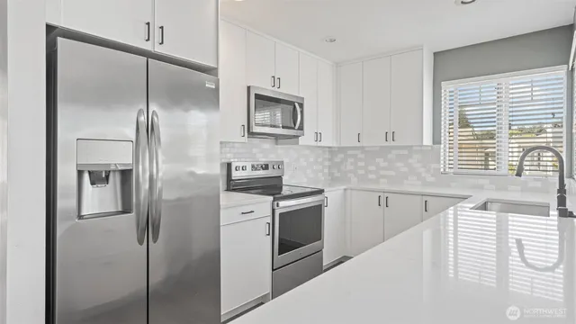 a kitchen with stainless steel appliances cabinets a sink and a window