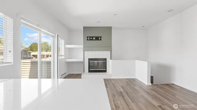 a view of a livingroom with wooden floor and a fireplace