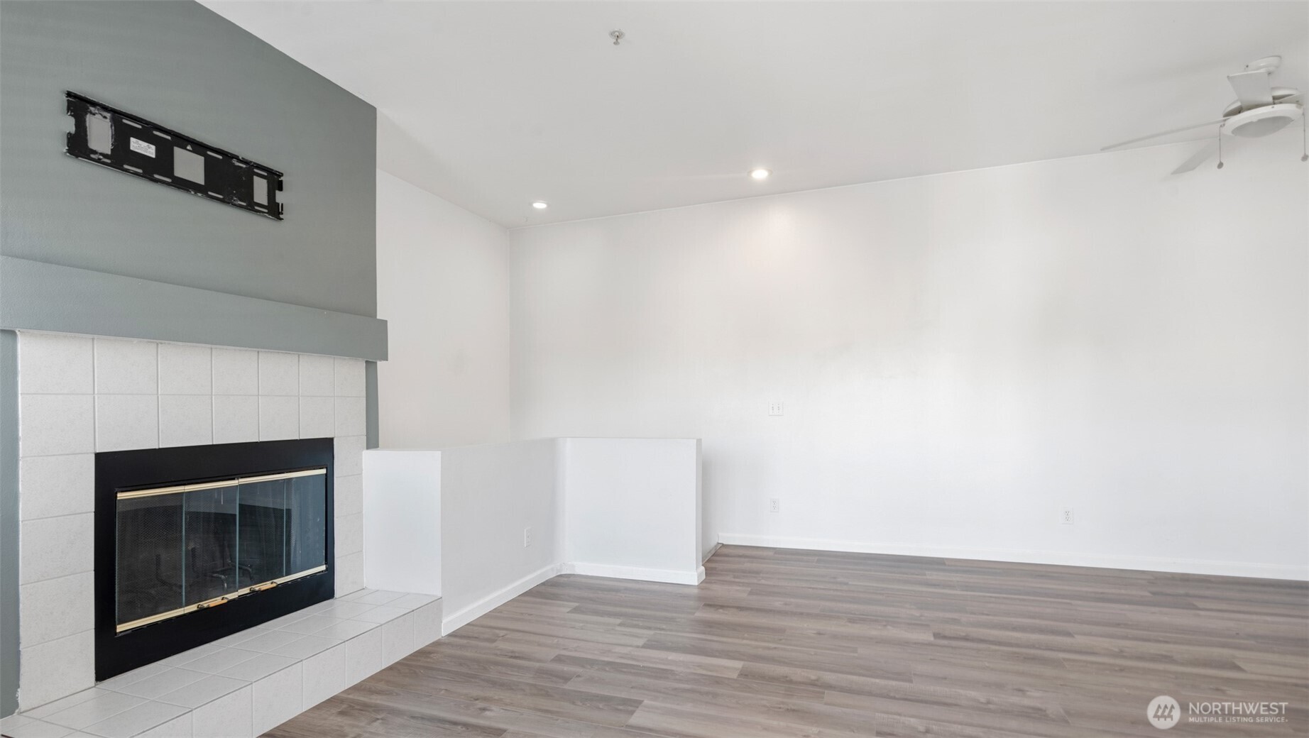 23118 59th Place South, Unit 154 Kent, WA 98032 - Photo 10 of 25 a view of an empty room with wooden floor and a fireplace