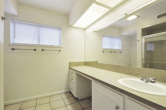 2819 San Gabriel Street, Unit A Austin, TX 78705 - Photo 18 of 21 a bathroom with a sink a mirror and a shower