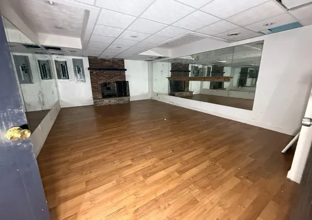 a view of a hallway with wooden floor and a kitchen