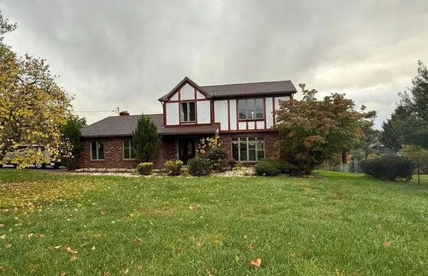a front view of a house with a yard and trees